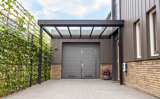 Design overkapping met glazen dak en carport in moderne stijl – Van Beem Buitenleven