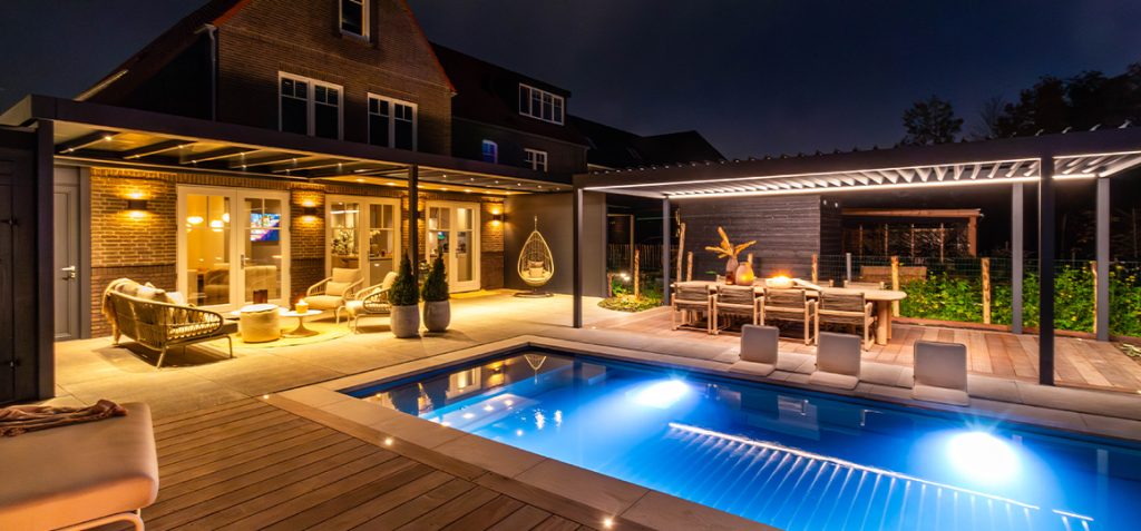 Overkapping met glazen dak en lamellenoverkapping bij zwembad met Suns en Gommaire tuinmeubelen