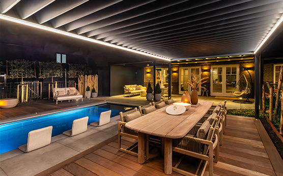 Gommaire Carlo low dining set under slatted roof next to swimming pool – Van Beem Outdoor Living