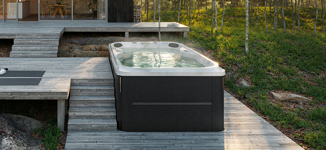 Jacuzzi J-13 PowerPlay zwemspa in Smoked Ebony in de tuin voor luxe wellness en zwemmen buiten
