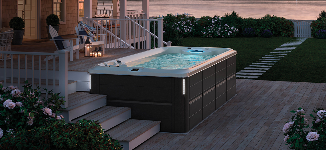 Jacuzzi J-19 PowerActive swim spa in Smoked Ebony in the garden for luxurious wellness and outdoor swimming